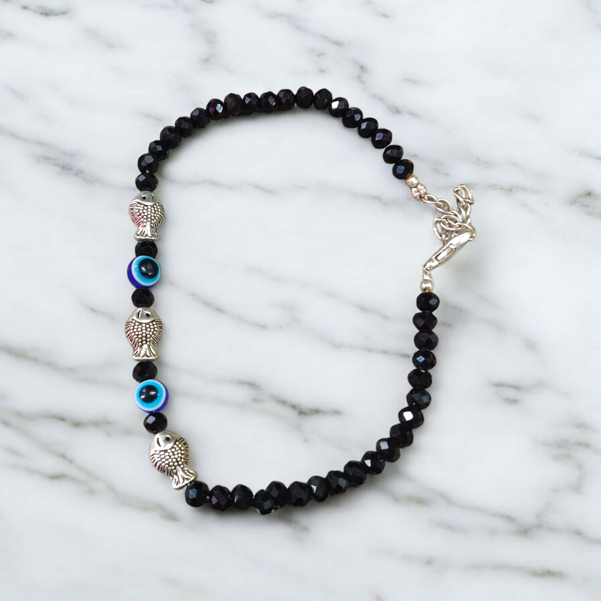 Unisex black crystal beads anklet featuring protective Evil Eye and lucky Fish charms, handcrafted for spiritual style and daily wear