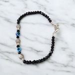 Unisex black crystal beads anklet featuring protective Evil Eye and lucky Fish charms, handcrafted for spiritual style and daily wear