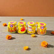 Yellow chandan paste container used for tilak, puja, and religious rituals