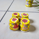 Yellow chandan paste container used for tilak, puja, and religious rituals