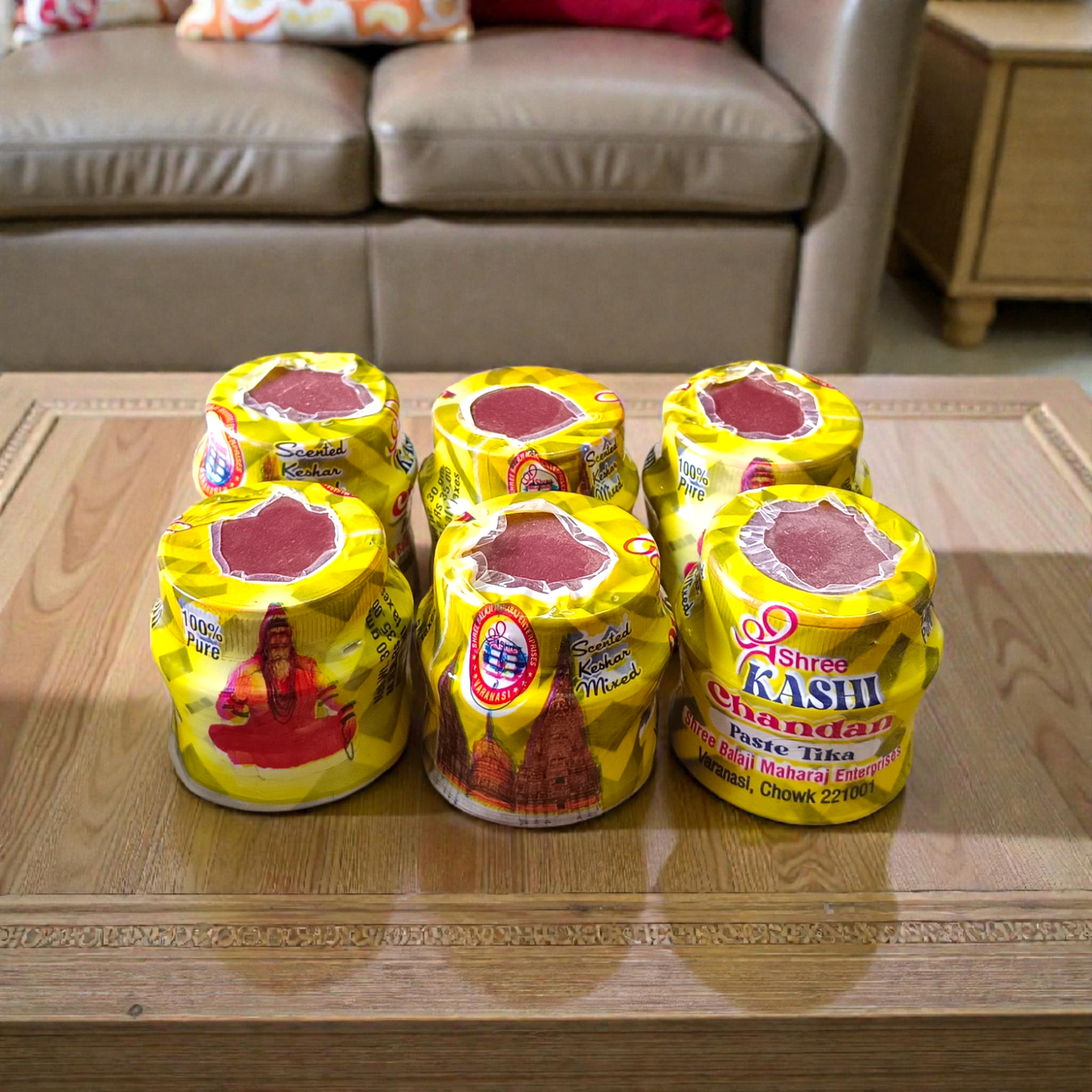Yellow chandan paste container used for tilak, puja, and religious rituals