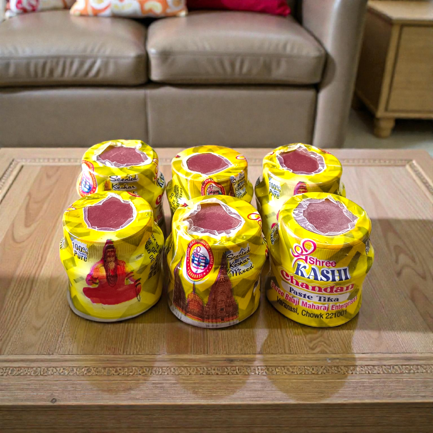 Yellow chandan paste container used for tilak, puja, and religious rituals